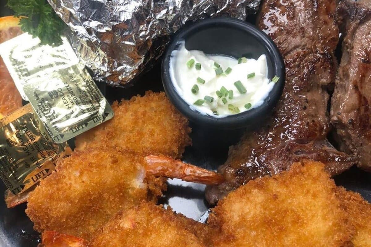 Garlic butter sirloin bites with baked potato and salad